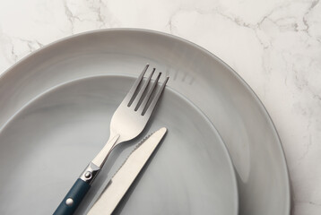 Plates with cutlery on marble background. Table setting