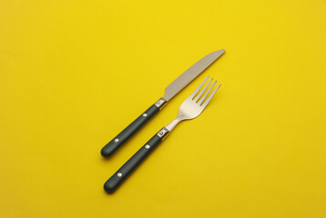 Fork and knife on yellow background