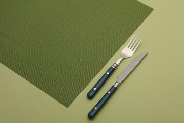 Fork and knife on green background