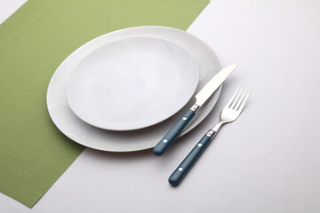 Set of dishes and cutlery for table setting on white background