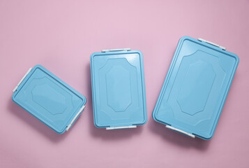 Blue Plastic containers for storing food on a pink background. Top view
