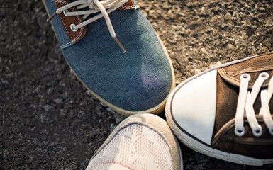 Closeup of shoes in a huddle with their feet together showing unity and teamwork. Friendship, happiness, and partnership team concept. - Powered by Adobe