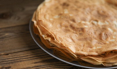 Stack of pancakes on a plate, wooden table