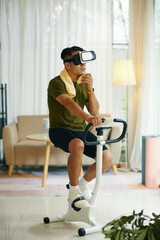 A man using a VR headset while riding a stationary bike in a stylish, modern living room with plants and bright lighting