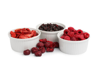 Bowls of dried berries on white background