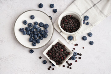 Bowls with freeze-dried blueberries on white background