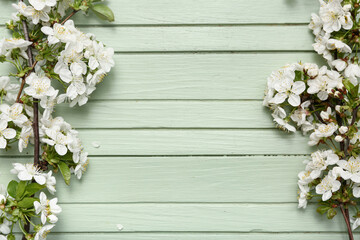 Beautiful blossoming branches on green wooden background