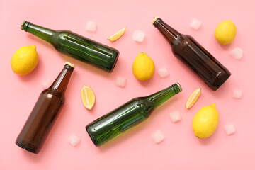 Bottles of fresh beer with lemon and ice cubes on pink background