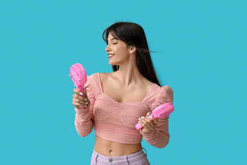 Young woman with mini fans on blue background