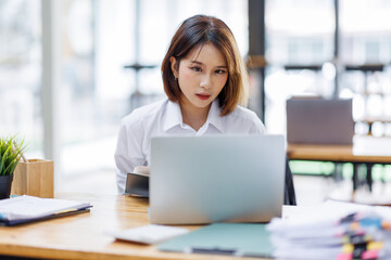 Fototapeta premium Portrait of happy asian female employee at computer
