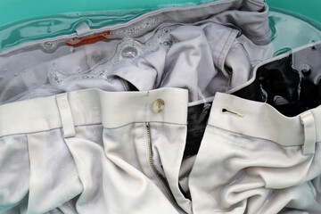 Trousers soaked in powder detergent water dissolution, washing cloth. Laundry concept