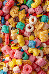 A close-up view of a bowl filled with colorful cereal pieces, densely packed to fill the entire frame. The cereal features a variety of shapes and bright colors, creating a fun and playful background 