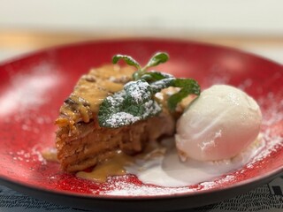 A Slice of Apple Pie With Ice Cream and Powdered Sugar on a Red Plate