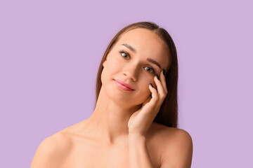 Young woman with beautiful eyebrows on lilac background