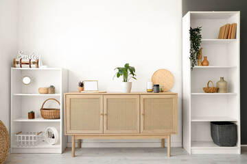 Interior of living room with shelf units, plants and air humidifier on commode