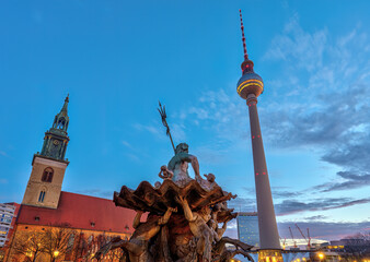 The TV Tower, the Marienkriche and the Neptune fountain at the Alexanderplatz in Berlin at dawn