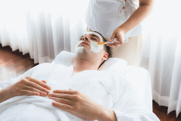Serene ambiance of spa salon, man customer indulges in rejuvenating with luxurious face cream...