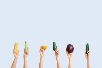 Female hands holding fresh vegetables on white background