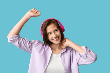 Fototapeta premium Beautiful young woman in modern headphones listening music on blue background