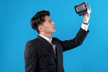 Asian businessman in serious face checking through VR connecting to financial report in futuristic...