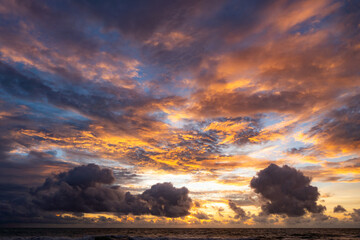 Dramatic sunset over storm clouds. Beautiful red color sky. Red purple orange blue pink sunset cloud background. Concept holiday in the tropics