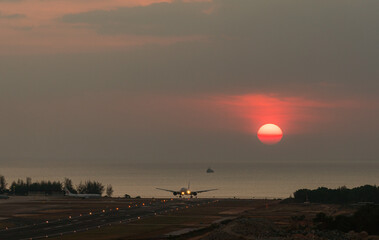 an airplane landing at an airport during sunset sky