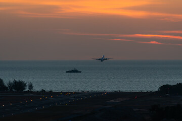 ack view silhouette of Runway landing at the airport at sunny orange and purple sunset. Runway.