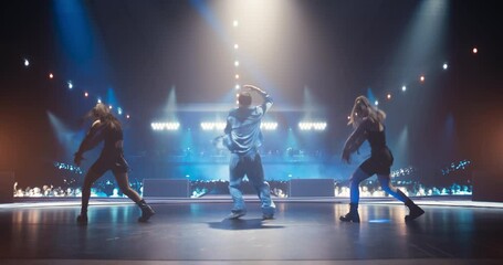 Young K-Pop Singer in Blue Costume Performing a Solo Concert with Show Girls on a Festival Stage. His Charismatic Stage Presence and Lyrics Electrify the Diverse Music Fans in Crowded Arena