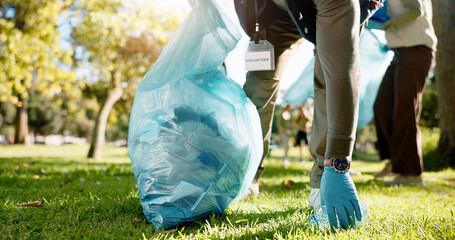 Hand, person and charity with pick up dirt at park with plastic for cleaning, care and community...