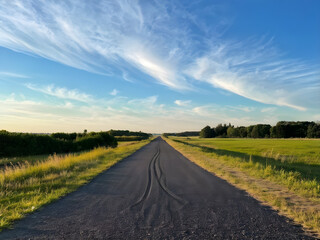 Fototapeta premium A road with tire tracks on it and the sky is background beauty nature