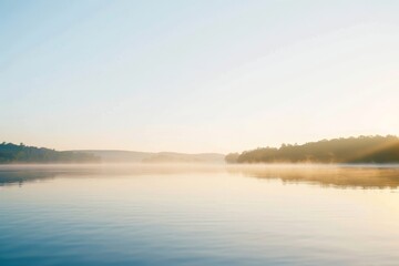 Fototapeta premium A tranquil lake scene at sunrise with a clear sky, leaving a large area of empty space for text.