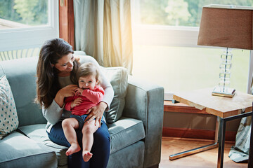 Mother, child and happy on couch in home with relax, bonding and love with embrace for fun together. Family, woman and daughter or kid with smile for trust, care and security in living room of house