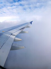 Obraz premium clouds and wing of the airplane seen from the window
