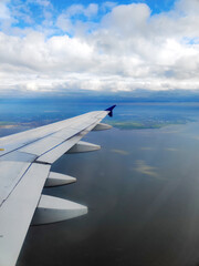 Obraz premium clouds and wing of the airplane seen from the window