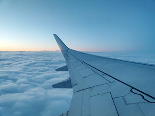 Obraz premium clouds and wing of the airplane seen from the window