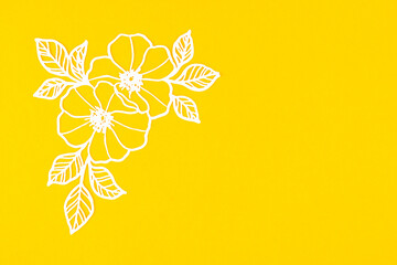 White flower and leaves made from carve paper or cutting on yellow background.