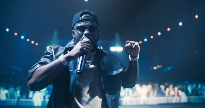 Portrait of a Male Rapper Singing an Emotional Song. Spectacular Concert with a Talented Hip Hop Star. His Soulful Voice and Catchy Tunes Keep the Audience Vibing to the Sounds of Modern Music