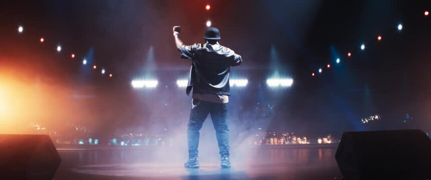 Fans Experiencing a Powerful Musical Performance by a Talented African Hip Hop Artist. Singer Works on Stage With a Blend of Emotion and Energy. Back View Footage. Anamorphic Shot