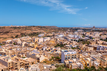Obraz premium Scenic view of Victoria city from Gozo island in Malta. Cityscape with numerous buildings under a clear blue sky