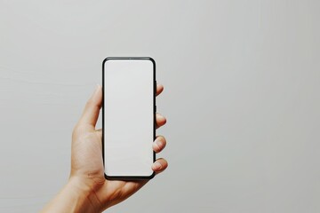 a person's hand holding a smart phone against a gray and white wall