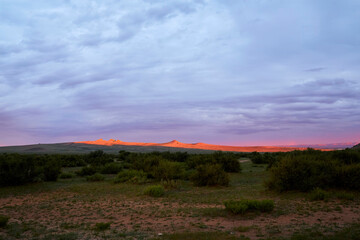 In the early morning in Burd, Mongolia, the sky over the ger camp and the rocky mountains painted in the brilliant colors of the Blue Hour