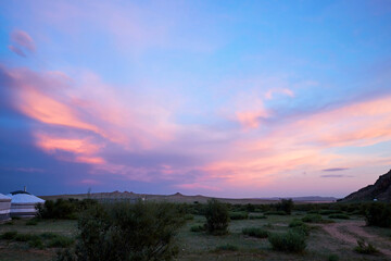 In the early morning in Burd, Mongolia, the sky over the ger camp and the rocky mountains painted in the brilliant colors of the Blue Hour