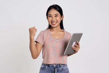 Smiling cheerful happy beautiful young Asian woman in a casual t-shirt holding digital tablet pc...