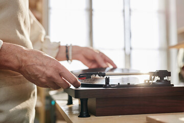 Side view close up of senior woman setting up vinyl record in sunlight copy space