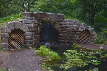 Decorative stone grotto and pond in a romantic corner of the garden