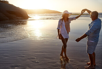 Mature, happy couple and dancing with beach sunset for love, bonding or playing in nature. Man,...