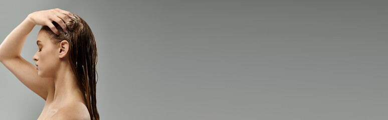 Fototapeta premium Woman with long hair stands gracefully washing hair.