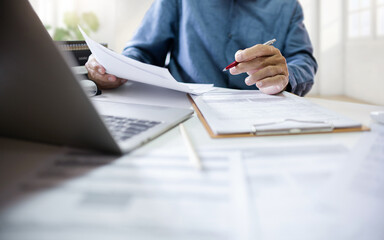 Asian businessman using computer laptop working and meeting online to review document report at office. legal expert, professional lawyer reading and checking business report or insurance contract