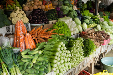 Beautifully arranged fresh vegetables at a traditional market, for sale.