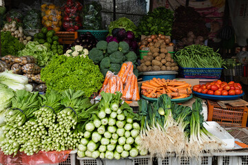 Beautifully arranged fresh vegetables at a traditional market, for sale.